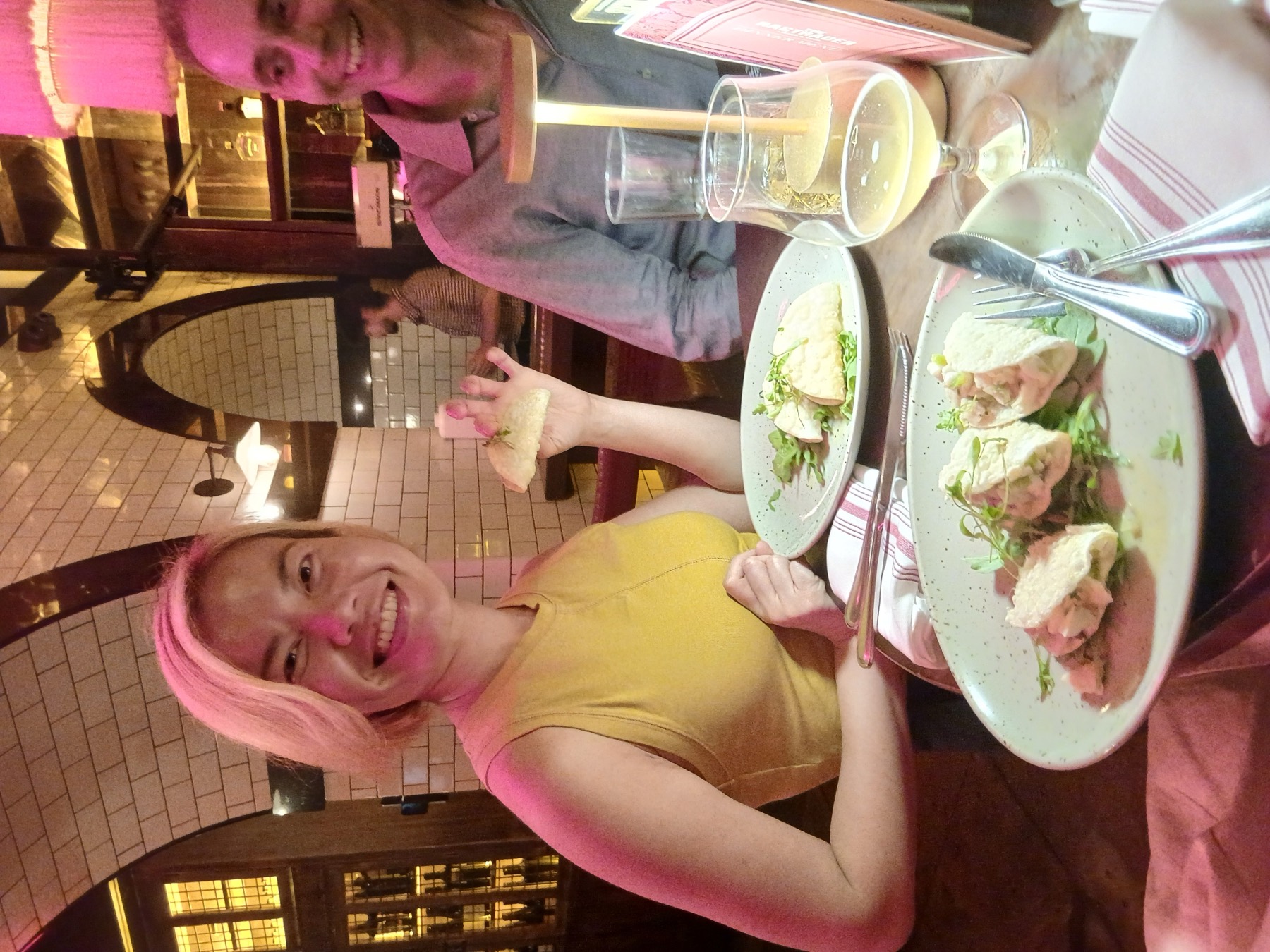 A Bunch member laughing over dinner and wine